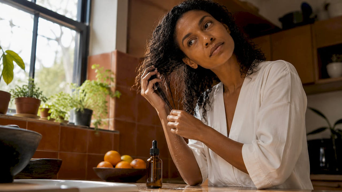 Woman applying hair oil to curly strands